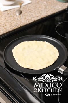 an uncooked tortilla being prepared in a skillet on the stove