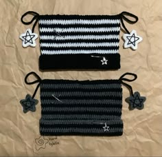 two black and white crocheted bags with stars on them sitting on a brown sheet