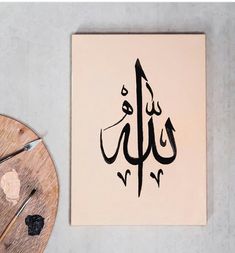 an arabic calligraphy is displayed on the wall next to a piece of wood and scissors