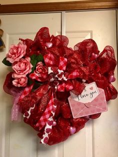 a heart shaped wreath is hanging on the front door