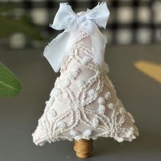 a small white christmas tree sitting on top of a table