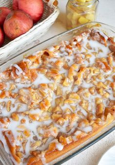 a glass pan filled with food next to apples