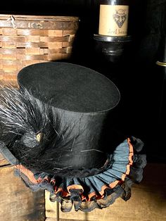 Small antique Gothic top hat that I embellished with a Victorian hat pin, old black hat feather, ruffled Dennison crêpe paper streamers and old black lace, giving it a fun wicked Halloween spirit.  This hat would be great as a costume hat or Holiday wear.  It looks wonderful on a human or a mannequin or a statue. It is petite so it will probably fit a woman better than a man.  Sold as found showing minor signs of age wear, see photos. It is small and measures approximately 21 1/4" inside brim circumference.  It is a collapsible top hat from the 1930's or so but in order to collapse it you would need to remove all the decorations which are only pinned on.  Made by "Saltz Brothers - Fine Apperal for Gentlemen" Washington, DC  This listing is for the top hat with with embellishments shown onl Black Brimmed Top Hat For Themed Events, Black Fitted Top Hat For Themed Events, Fitted Black Top Hat For Themed Events, Steampunk Mini Hat With Curved Brim, Steampunk Black Curved Brim Mini Hat, Steampunk Black Mini Hat With Curved Brim, Vintage Black Fascinator For Costume Party, Vintage Black Hat With Feathers, Black Hat Bands For Halloween Costume