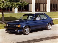 a blue station wagon parked in front of a building