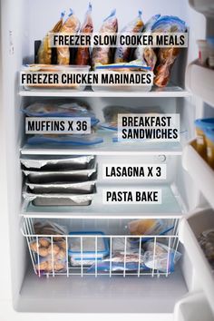 an open refrigerator filled with lots of food and freezer labels on the door,