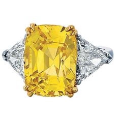 Three-stone ring composed of platinum and 18K yellow gold. The ring features a 16.79 carat cushion cut yellow sapphire. The sapphire is accompanied by a GIA report, stating the stone is natural with no heat treatment. The sapphire is flanked by two trillion-cut diamonds, one of which is 1.36 carats and the other 1.45 carats, H-I color and SI1 clarity, respectively. The ring is a size 6 1/2 and may be sized within reason. Cushion Cut Sapphire Ring, Trillion Diamonds, Cushion Cut Diamond Ring, Contemporary Engagement Rings, Yellow Sapphire Rings, Sapphire And Diamond Ring, White Diamond Ring, Three Stone Diamond, Engagement Ring Diamond Cut