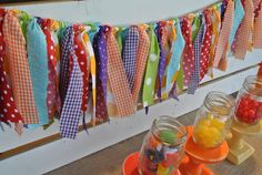 colorful streamers are hanging from the wall above jars filled with candy and candies