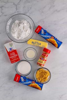 the ingredients to make an orange cake sitting on a marble counter top, including butter, flour, eggs, and other items