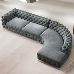 a large gray couch sitting on top of a white carpeted floor next to a rug