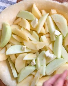 an uncooked pie crust with apples and cheese