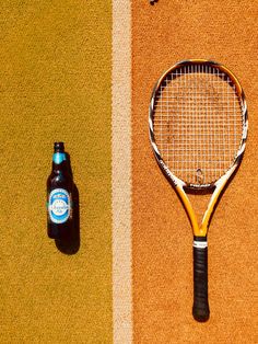 a tennis racket and beer on the ground next to a carpeted area with two different colors