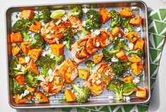 broccoli, carrots and other vegetables are on a baking sheet with a lime wedge