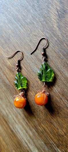 Adorable  Handmade  Pumpkin earrings approximately 2" in length. Copper wire wrapped orange beads with leaf charm. Orange Czech Glass Jewelry With Ear Wire, Orange Wire Wrapped Earrings For Gift, Orange Copper Wire Wrapped Jewelry, Orange Czech Glass Dangle Earrings, Orange Copper Dangle Earrings, Handmade Orange Copper Earrings, Nickel Free Copper Orange Earrings, Nickel-free Copper Orange Earrings, Nickel-free Orange Copper Earrings