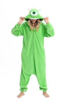 a woman in a green monster costume is covering her eyes with one hand while standing against a white background