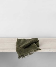 a green blanket sitting on top of a wooden table