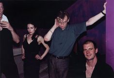 a group of people standing next to each other in front of a purple and black wall