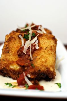 a white plate topped with meat covered in sauce