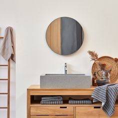 a bathroom with a sink, mirror and towel hanging on the wall next to it