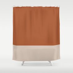 a shower curtain with an orange and white stripe on the bottom, in front of a gray background