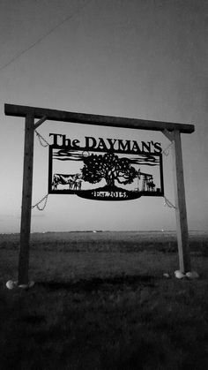 the sign for the davman's is in front of an empty field