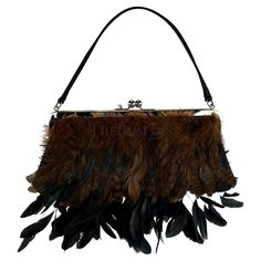 Presenting a black satin and brown feather Dolce and Gabbana evening bag. From the Fall/Winter 1997 collection, this bag debuted on the season's runway. The design is adorned with a prominent silver-tone kiss lock closure, a sleek black satin handle and body, and an exquisite combination of long and short black feathers. Whether you're attending a special event or seeking to elevate your night out, this fabulous bag is a true testament to Dolce and Gabbana's timeless elegance. Prepare to be enamored by the allure of this vintage runway masterpiece. Approximate measurements: 5.25" strap drop 11.5" width 1" depth 5" height (not including strap or feathers) 13" total length Dolce And Gabbana Runway, Vintage Runway, Satin Noir, Black Feathers, Dolce & Gabbana, Black Satin, Silk Satin, Fashion Handbags, Evening Bags