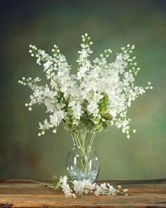 a vase filled with white flowers on top of a wooden table