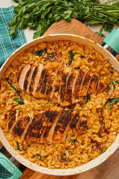 chicken and rice in a skillet on a wooden cutting board