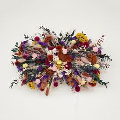 an arrangement of dried flowers on a white background