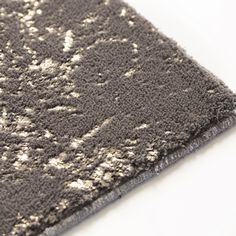 a close up view of an area rug with silver and white designs on the edges