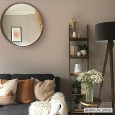 a living room filled with furniture and a round mirror