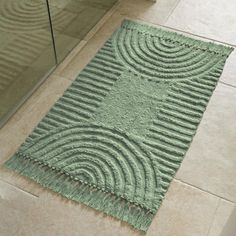 a green rug on the floor in a bathroom