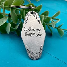 a metal keychain with the words buckle up entrepre written on it