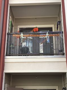 an apartment balcony decorated for halloween with decorations on the balconies and pumpkins