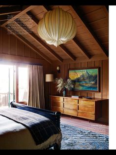 a bedroom with wood paneling and a large painting on the wall above the bed