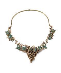 "Absolutely STUNNING vintage necklace by Richard Kaish! Circa 1991, this unique studio necklace features a handmade grapevine collar in bronze, copper, and \"antique verdigris\" enamel. The details on this piece are exquisite, from the burnished, brutalist grapes to the art nouveau-inspired leaf and vining patterns. The collar measures a wearable 18\" long and closes at the side via a custom hook and eye latch. Although these grape necklaces were a fairly common motif for Richard Kaish, this par Antique Enamel Necklaces For Wedding, Antique Enamel Necklace For Wedding, Artistic Enamel Jewelry For Formal Occasions, Vintage Gold Necklaces With Patina, Artistic Enamel Necklace For Collectors, Vintage Metal Necklace With Patina, Vintage Patina Metal Necklace, Antique Enamel Necklace For Formal Occasions, Brutalist Art