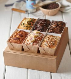 an open box of assorted pastries on a table