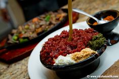 a bowl filled with food sitting on top of a white plate next to other dishes