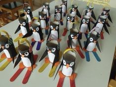 a group of penguins made out of construction paper and some scissors on top of a table