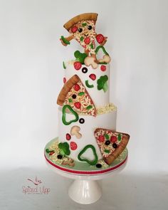 a three tiered cake decorated with pizza and toppings