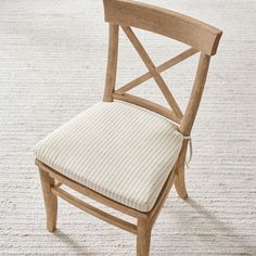 a wooden chair sitting on top of a white carpet