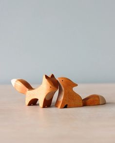 two wooden toy foxes sitting next to each other