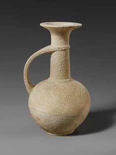 an old white vase is sitting on a gray background