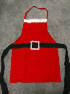 a santa claus apron on the floor with a black belt around it's waist