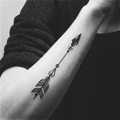 a woman's arm with an arrow tattoo on it