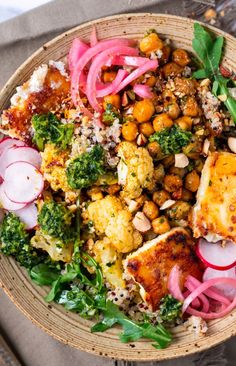 a bowl filled with vegetables and meat on top of a table