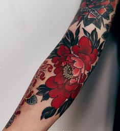 a woman's arm with red flowers on it