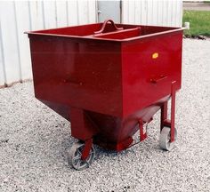 a red wagon sitting on top of gravel