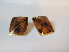 Vintage pierced square gold-toned earrings with multi swirl brown, orange, and gold colors. In middle of earrings is a gold swirl Deco.  These earrings have a lacquer overlay. Made and stamped by Berebi  Circa 1980's H=1 1/8 in  W=bottom 3/4 in (.75 in) W=top=.80 in  Excellent condition  US SHIPPING  FREE  International shipping please see rate Please add our shop as a ❤ favorite so you can find us again! Our website is MinxandOnyx.com Www.facebook.com/minxandonyx @minxandonyx follow us on Instagram  Thank you for shopping at Minx and Onyx! Vintage Pierced Enamel Earrings, Retro Enamel Earrings As Gift, Vintage Black Enamel Earrings For Gifts, Vintage Enamel Clip-on Earrings, Vintage Hand Painted Enamel Earrings, Vintage Hand-painted Enamel Earrings, Vintage Black Enamel Earrings, Amazing Earrings, 80s Earrings