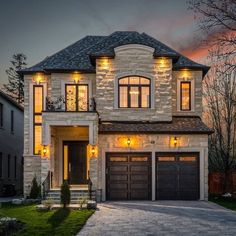 a large house with two garages and lights on the front door is shown at night