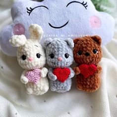 three small crocheted stuffed animals sitting next to each other on a white blanket